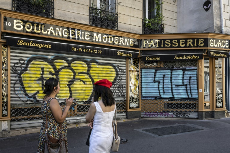 Des visiteurs se tiennent devant la Boulangerie Moderne à Paris le 27 août 2024