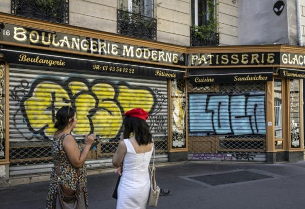 Des visiteurs se tiennent devant la Boulangerie Moderne à Paris le 27 août 2024
