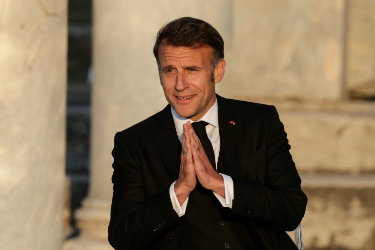 Le président français Emmanuel Macron salue le public à son arrivée sur scène lors d'un événement à l'Agora romaine d'Athènes, le 24 avril 2026 en Grèce