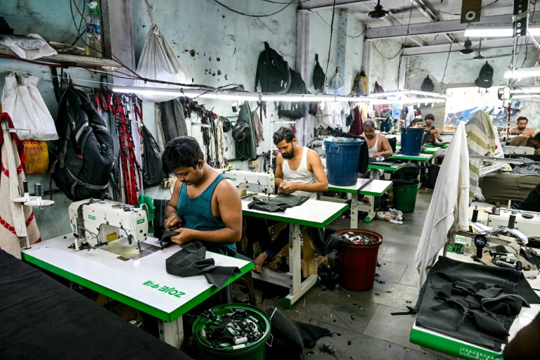Des ouvriers dans une atelier de fabrication de vêtements dans le bidonville de Dharavi, le 12 juillet 2025 à Bombay, en Inde