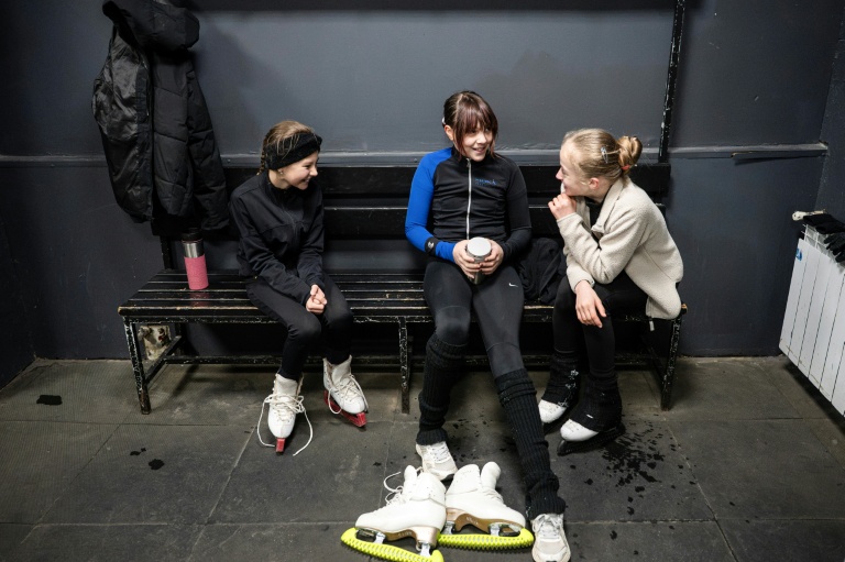 Trois jeunes patineuses prennent une pause lors d'un entraînement dans une patinoire de Kiev, le 16 octobre 2026 