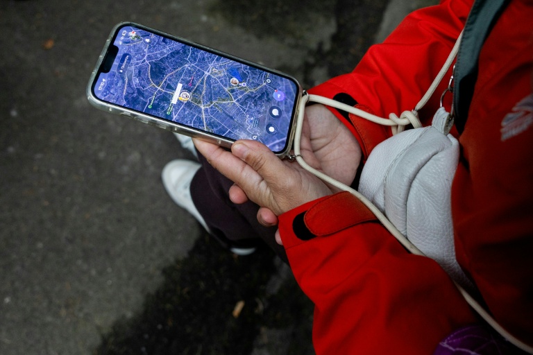 Anastassiia Jmoutska suit les déplacements de son fils Orest sur une carte affichée sur son smartphone, le 13 octobre 2026 à Kiev, en Ukraine