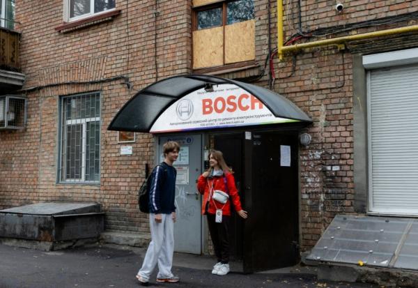 Anastassiia Jmoutskaet son fils Oreste se rendent à l'école après une alerte aérienne, à Kiev, le 13 octobre 2026 en Ukraine