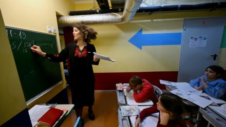 Des écoliers ont classe dans un abri installé au sous-sol de leur école primaire pendant une alerte aérienne en banlieue de Kiev, le 20 octobre 2026