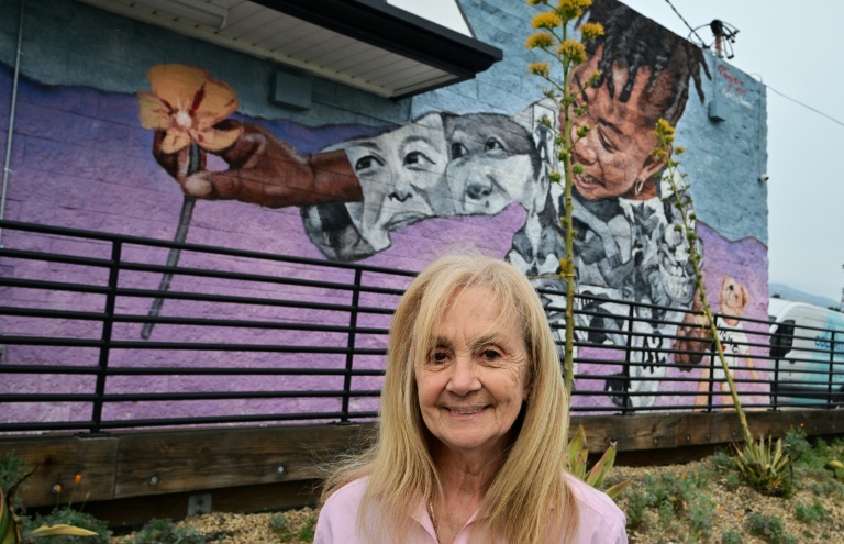 Roxanne Albee, une habitante d'Altadena, devant un fast-food décoré d'une fresque murale en hommage aux pavots de Californie, le 30 mars 2026