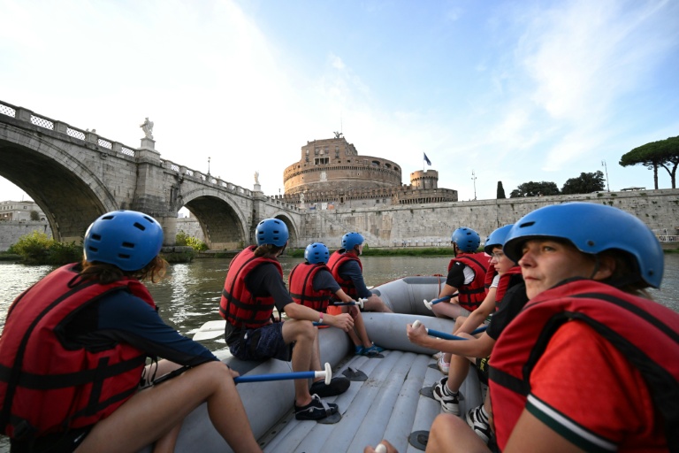 Des personnes naviguent en canot pneumatique sur le Tibre, passant devant le château Saint-Ange, sur un tronçon du fleuve situé entièrement dans la zone urbaine du centre de Rome, le 14 août 2026