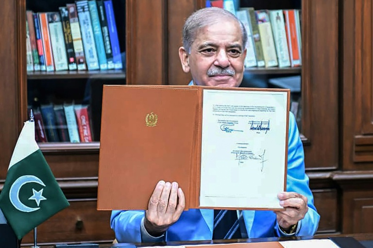 Le Premier ministre pakistanais Shehbaz Sharif montre le protocole d'accord signé par les présidents américain et iranien, après l'avoir lui-même signé en tant que médiateur, le 18 juin 2026 à Islamabad