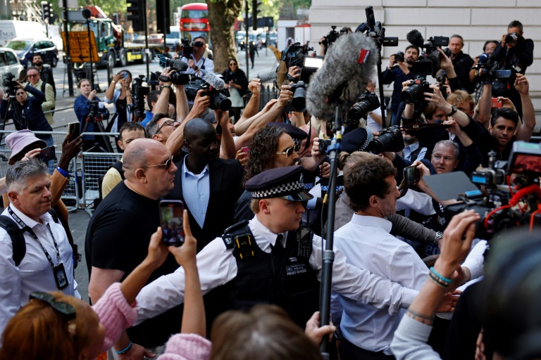 Le comédien britannique Russell Brand (c), poursuivi pour viols et agressions sexuelles, arrive au tribunal de Westminster à Londres, le 2 mai 2025
