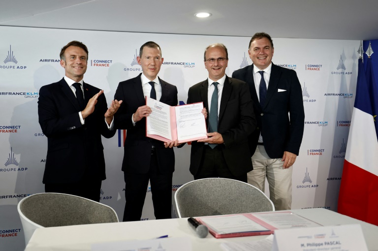 Le président français Emmanuel Macron, le directeur général d'Air France-KLM Ben Smith, le PDG du groupe ADP Philippe Pascal et le ministre des Transports Philippe Tabarot lors de la signature d'un partenariat stratégique entre Air France-KLM et ADP au salon du Bourget, pès d Paris, le 20 juin 2025 
