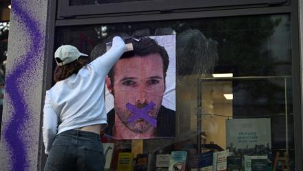 Une militante féministe colle une affiche dénonçant la publication d'un livre de Nicolas Bedos, condamné en octobre pour agressions sexuelles, le 23 mai 2025 à Paris