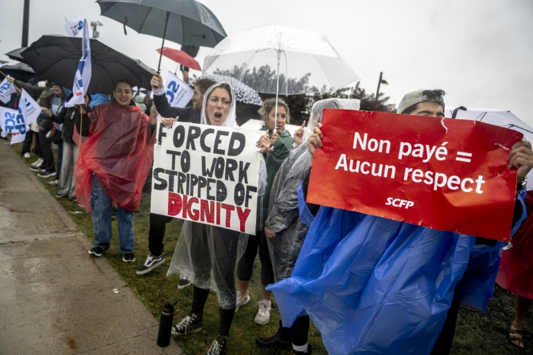 Des hôtesses et stewards manifestent devant l'aéroport Pierre-Elliott Trudeau à Montréal, au Québec, le 17 août 2025 au Canada