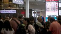 Des voyageurs consultent un panneau d'information sur les vols annulés d'Air Canada à l'aéroport Pierre-Elliott Trudeau à Montréal, au Québec, le 17 août 2025 au Canada