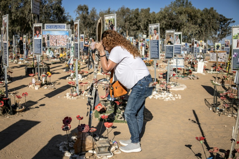 Une femme se recueille au mémorial dédiés aux victimes des attentats du 7 octobre 2023, sur le site du festival Nova à Reim, dans le sud d'Israël, à l'occasion du deuxième anniversaire des attaques, le 7 octobre 2025