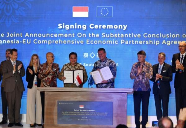 Le ministre indonésien de l'Economie, Airlangga Hartarto (au centre à g.), et le commissaire européen au commerce, Maros Sefcovic (au centre à d.), posent sur scène après avoir paraphé l'accord de libre-échange entre l'Indonésie et l'UE sur l'île indonésienne de Bali, le 23 septembre 2025