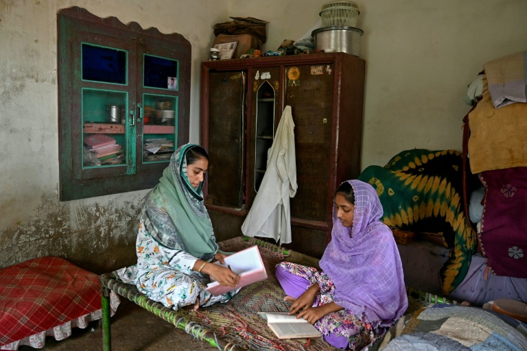 Durga Prem (g), étudiante en ingénierie informatique et sa soeur Mumta, chez elle à Badin, dans la province du Sindh, le 15 juillet 2025 au Pakistan