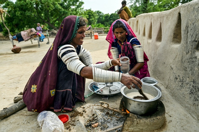 Jamna Kolhi (g) et sa parente Reshma, portant des tatouages et des tenues indigènes, préparent du thé au village de Ponjo Kolhi, à environ 30 km d'Umerkot, un district à majorité hindoue, le 14 juillet 2025 au Pakistan