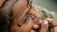 Un tatouage traditionnel est dessiné sur le visage de la jeune Champa, 7 ans, à la colonie Jogi à Umerkot, un district à majorité hindoue, le 14 juillet 2025 au Pakistan