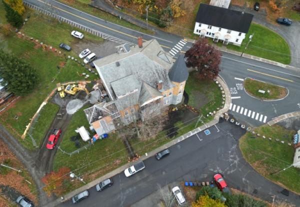 Cette vue aérienne montre la construction en cours d'un point d'accès canadien à la bibliothèque Haskell, qui est traversée par la frontière canado-américaine, marquée par des rochers, à Stanstead le 22 octobre 2025 