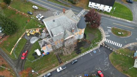 Cette vue aérienne montre la construction en cours d'un point d'accès canadien à la bibliothèque Haskell, qui est traversée par la frontière canado-américaine, marquée par des rochers, à Stanstead le 22 octobre 2025 