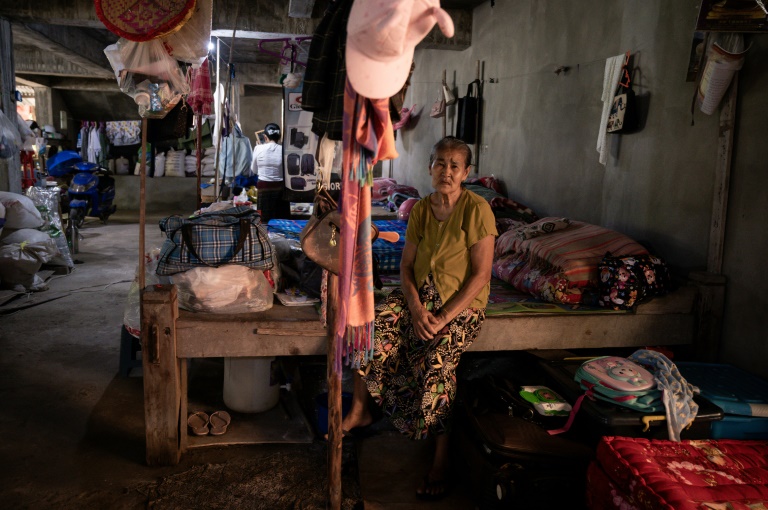 Une femme, déplacée par les combats entre l'armée birmane et l'Armée de l'indépendance kachin (KIA), étend du linge sur le terrain d'un monastère à Mandalay, le 16 septembre 2025 en Birmanie