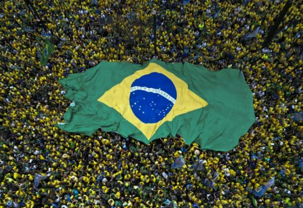 Des partisans de Flavio Bolsonaro, candidat du Parti libéral (PL) à la présidentielle, brandissent un immense drapeau brésilien lors d'un rassemblement à São Paulo, le 18 octobre 2026 au Brésil, avant le second tour de l'élection