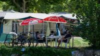Des vacanciers assis à l'ombre dans un camping au Bourget-du-Lac, le 8 août 2025 en Savoie