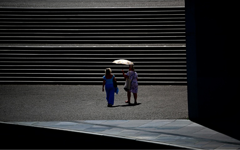 Des passantes se protègent du soleil sous une ombrelle à Berlin, pendant une vague de chlauer, le 26 juin 2026