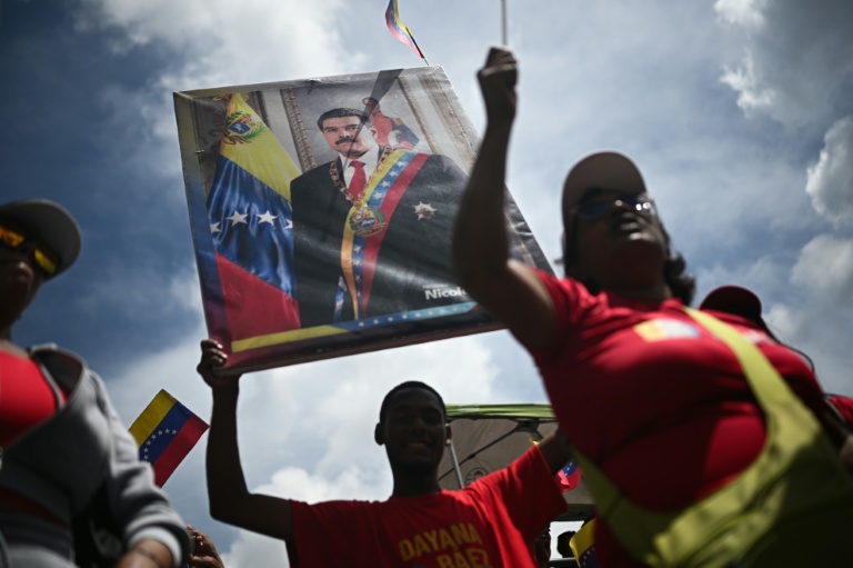 Un homme tient un portrait du président vénézuélien Nicolas Maduro, le 23 septembre 2025 à Caracas