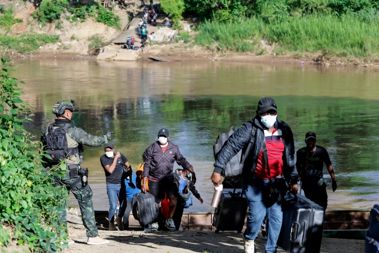 Des personnes de différents pays, qui travaillaient au complexe du parc KK en Birmanie, traversent en bateau la rivière Moei pour se rendre en Thaïlande, le 24 octobre 2025