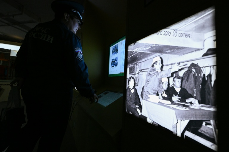 Un employé des services d'urgence ukrainiens consulte des informations sur l'accident de la centrale nucléaire de Tchernobyl, le 24 avril 2026 à Moscou, lors d'une exposition temporaire consacrée au 40e anniversaire de la catastrophe