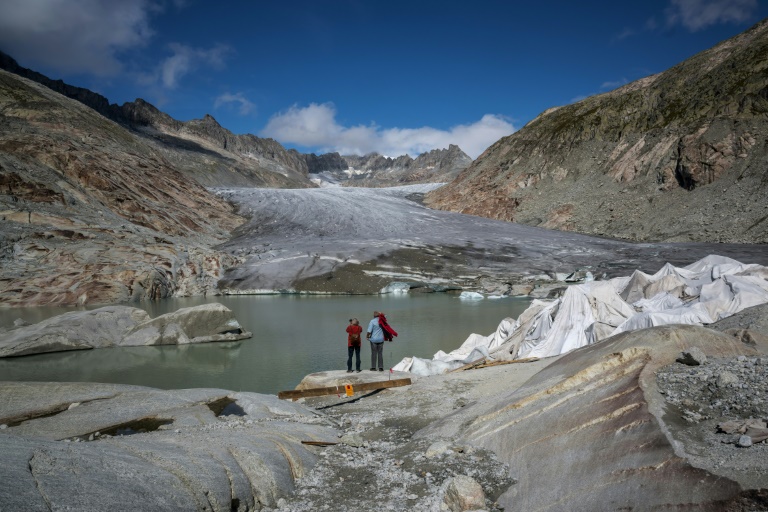 Des touristes devant le glacier du Rhône près de Gletsch, dans les Alpes suisses, le 12 septembre 2025