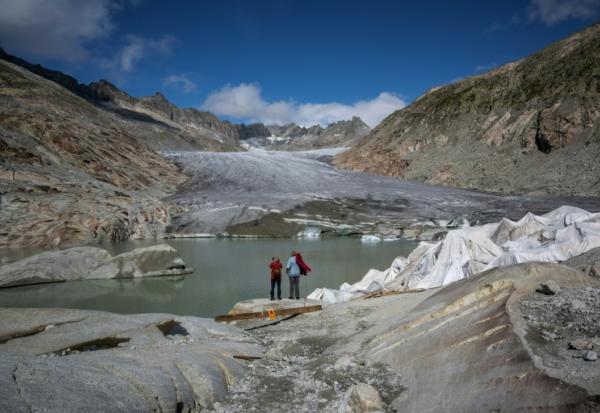Des touristes devant le glacier du Rhône près de Gletsch, dans les Alpes suisses, le 12 septembre 2025