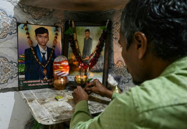 Suresh Patni, père d'Akash Patni, victime du crash du vol 171 d'Air India d'Air India, prie devant les portraits de son fils à son domicile d'Ahmedabad, le 8 novembre 2025 en Inde
