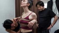 Une jeune femme attache les bras de sa modèle sous les yeux de Hajime Kinoko, l'un des plus connus artistes japonais de "shibari", l'art des cordes, le 26 mai 2025 à Tokyo
