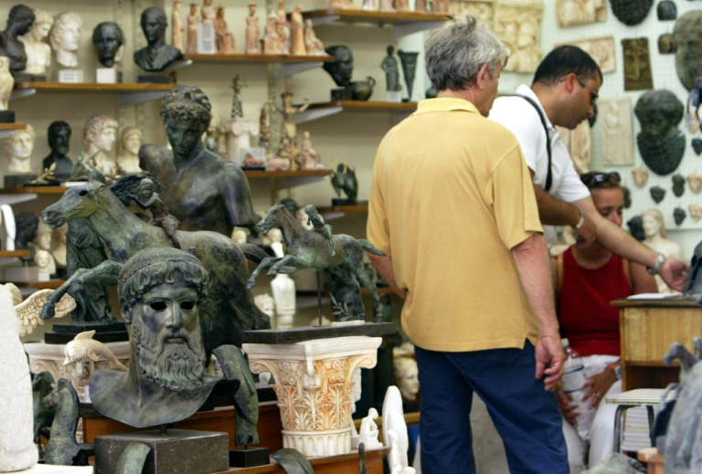 Des touristes dans une boutique de souvenirs du quartier historique de Plaka à Athènes le 05 août 2004