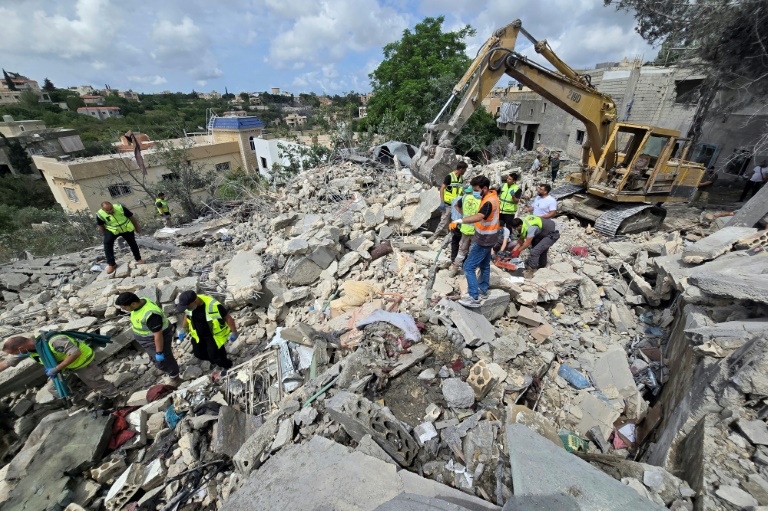Des secouristes de la protection civile libanaise fouillent les décombres à Deir Qanoun al-Nahr, dans le sud du Liban, le 20 mai 2026, au lendemain des frappes israéliennes