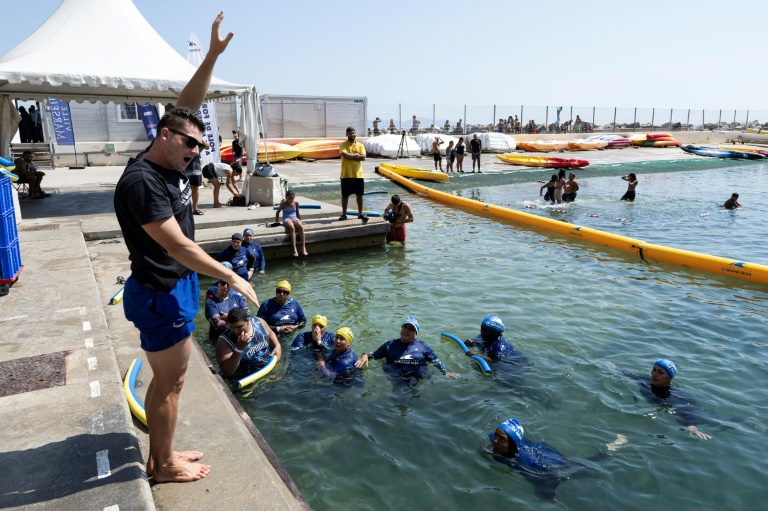 Des mères des quartiers Nord de Marseille écoutent un maître-nageur lors d'un cours de natation dispensé par l'association 