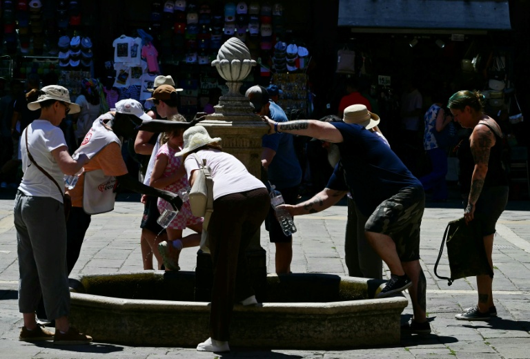 Des touristes se rafraîchissent à une fontaine publique à Venise, lors d'un épisode de canicule en Europe, le 27 juin 2026
