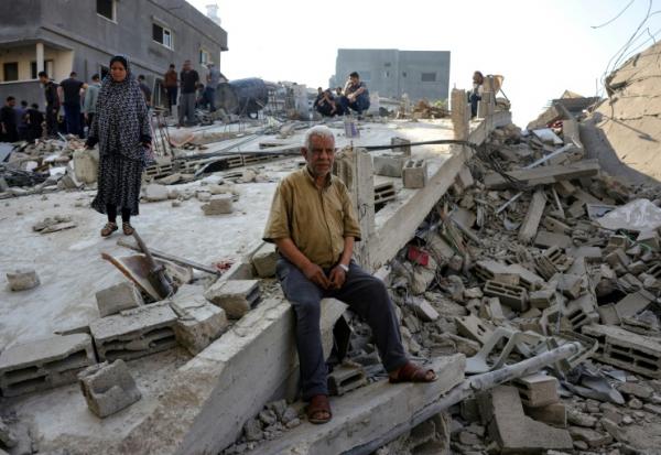 Des Palestiniens constatent les dégâts causés par une frappe israélienne ayant touché la maison d'une famille à Jabalia, dans le nord de la bande de Gaza, le 23 mai 2025