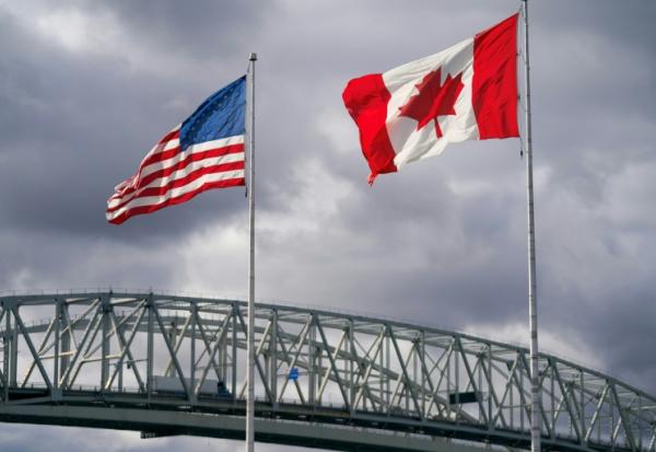 Les drapeaux américain et canadien près du poste frontalier du pont Blue Water à Point Edward, en Ontario, le 24 octobre 2025 au Canada