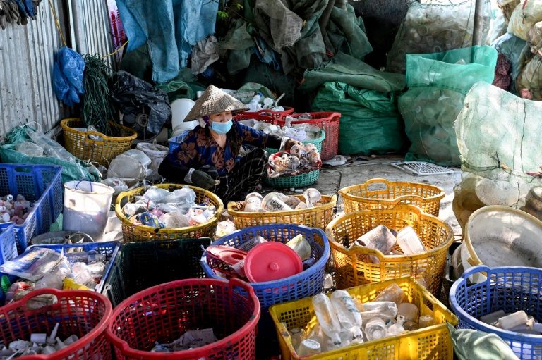 Une femme trie des déchets n plastique près de Hanoï, au Vietnam, le 25 novembre 2025