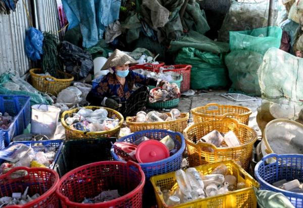 Une femme trie des déchets n plastique près de Hanoï, au Vietnam, le 25 novembre 2025