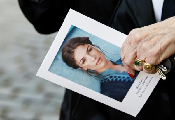 Un portrait de Nadia Farès tenu par une participante à ses obsèques, à Paris, le 24 avril 2026