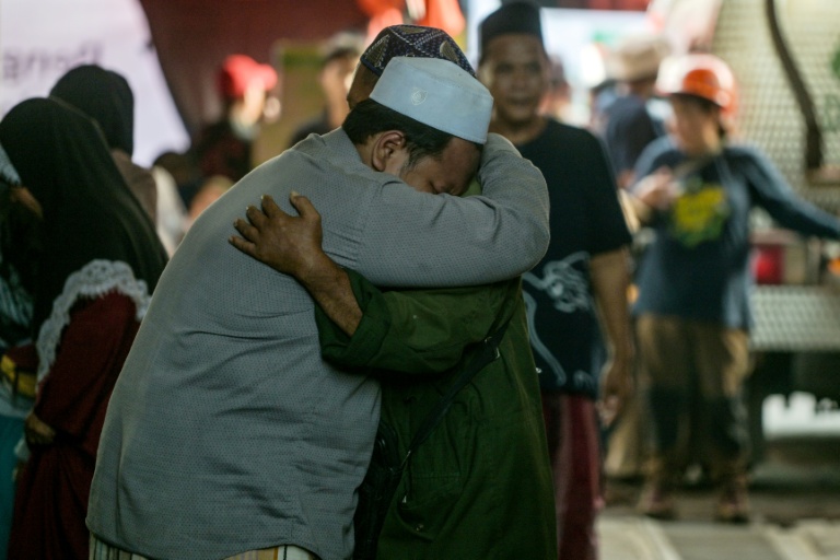 Des proches des écoliers disparus se confortent pendant que les opérations de recherche et de sauvetage se poursuivent à l'internat islamique Al Khoziny à Sidoarjo, dans la province de Java oriental, le 1er octobre 2025