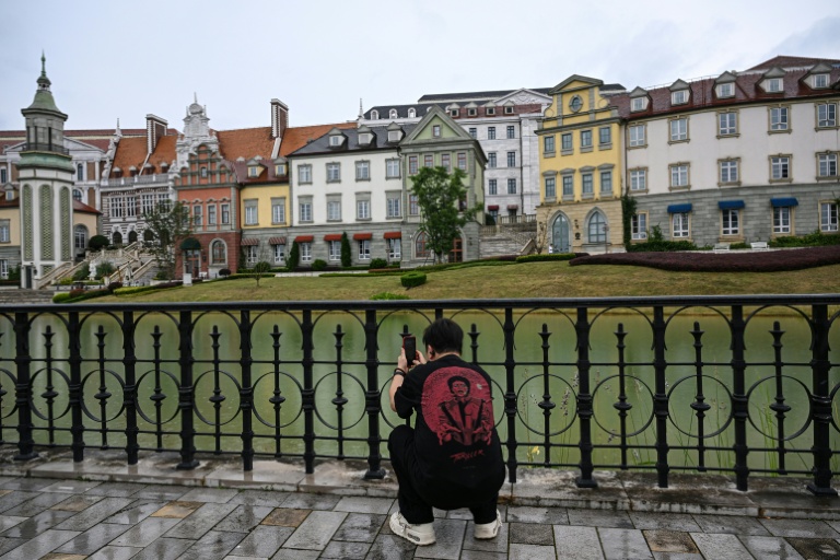 Un homme photographie le centre de données au style européen de l'entreprise technologique chinoise Huawei, situé dans la nouvelle zone de Guian, à Guiyang,d ans la province du Guizhou, le 24 juillet 2026 dans le sud-ouest de la Chine