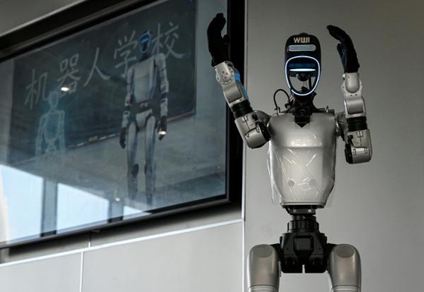 Le robot Wuji, fabriqué par Unitree, accueille des visiteurs pour une visite de l'école de robotique de Hangzhou, située dans la province du Zhejiang, dans l'est de la Chine, le 4 août 2026