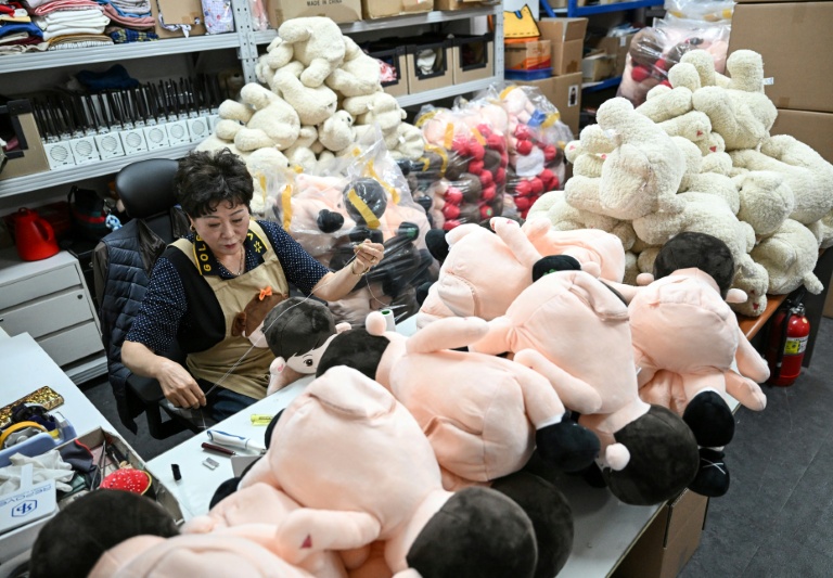 Une employée de la start-up Hyodol coud une poupée IA Hyodol, conçue pour les personnes âgées, le 6 mai 2026 au siège de l'entreprise à Anyang, en Corée du Sud 