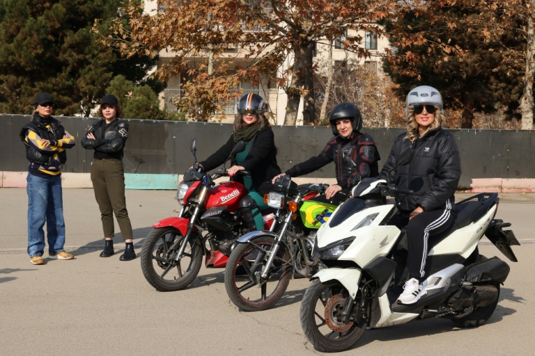 La monitrice Maryam Ghelich (g) et ses élèves Narghes (d), Elham (3e d), Leila et Mona lors d'un cours de conduite de moto dans un cente d'entraînement du nord de Téhéran, le 7 décembre 2025 en Iran