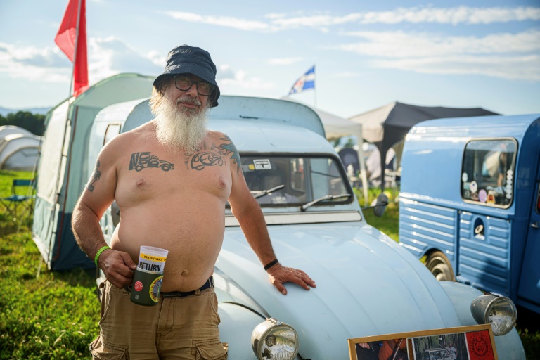 Gabriele Salvoni, un Italien de 55 ans, pose devant sa 2CV lors d'un rassemblement organisé à Postojna en Slovénie, le 30 juillet 2025