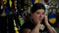 Svitlana Ostapenko, gérante du funérarium de Sumy, dans le nord-est de l'Ukraine, prépare, le 11 juin 2025, une croix et un couronne mortuaire pour l'enterrement d'un jeune soldat tué récemment lors de combats contre les forces russes